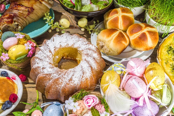 Uroczysta kolacja, brunch wielkanocny. Tradycyjne potrawy wielkanocne na rodzinnym stole domowym - pieczone mięso, quiche, wiosenna sałatka, muffinka, kolorowe jajka, gorące bułeczki krzyżowe