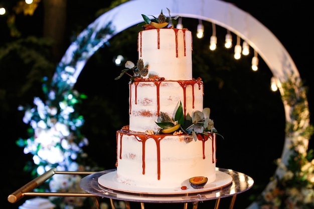 Uroczysty biały trzypoziomowy tort weselny