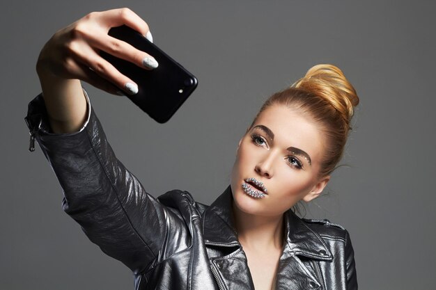 Uroda makijaż blondynka robi selfie