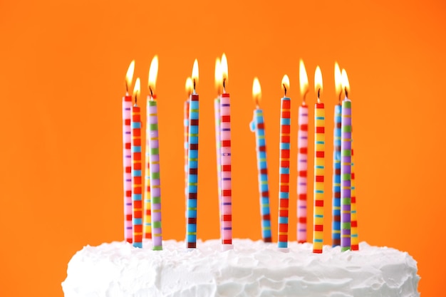 Urodzinowy tort z świeczkami na koloru tle