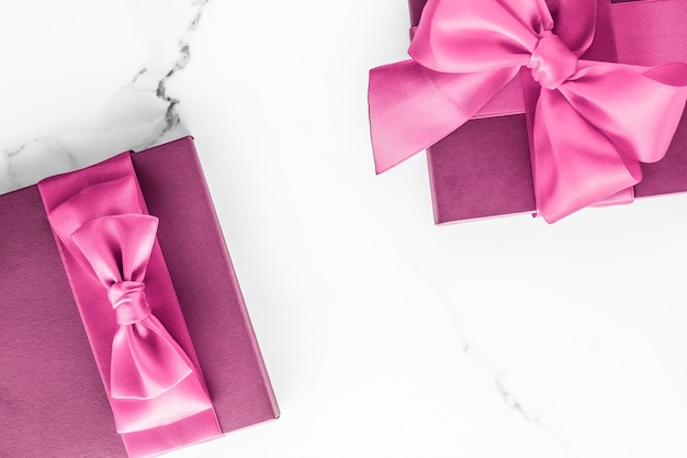 Urodziny ślub i dziewczęca koncepcja marki różowe pudełko z jedwabną kokardą na marmurowym tle dziewczyna prezent na baby shower i glamour moda prezent dla luksusowego piękna marka wakacje flatlay art design