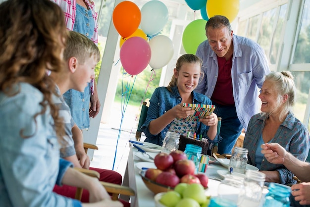 Zdjęcie urodziny w wiejskiej kuchni grupa dorosłych i dzieci zebrała się wokół ciasta czekoladowego