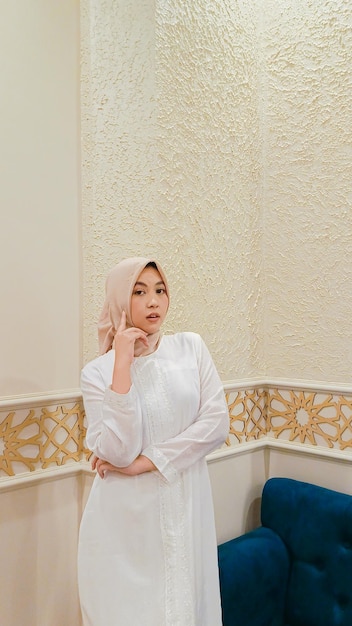 urok azjatyckiej kobiety w hidżabie z eleganckim wyrazem rąk skrzyżowanych i trzymającej ją