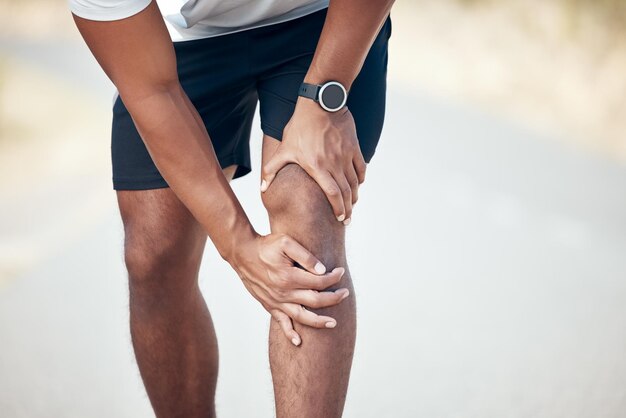 Zdjęcie uruchamianie bólu kolana i zbliżenie człowieka w mieście z powodu wypadku zapalnego i nagłego wypadku trening fitness i trening z nogami męskiego biegacza na drodze z powodu bólu mięśni urazy sportowe i pierwsza pomoc