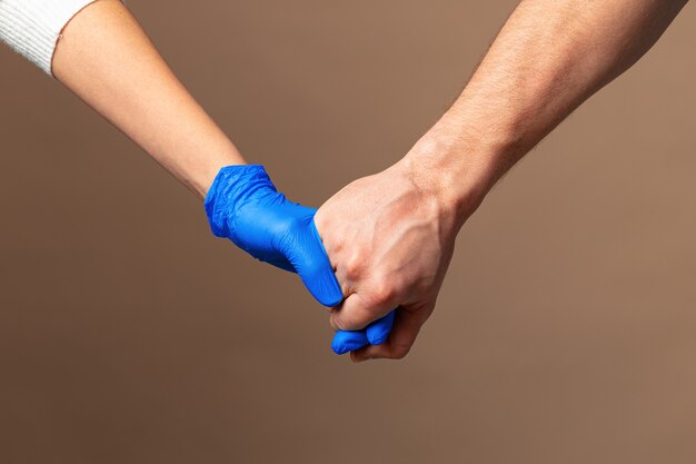 Uścisk dłoni w niebieskie rękawiczki, koncepcja pomocy. Higiena osobista podczas pandemii