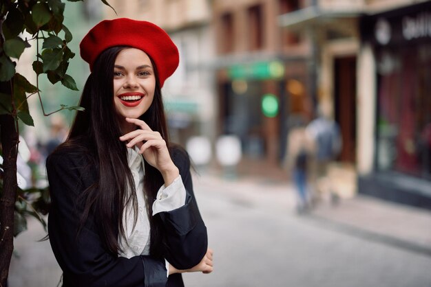 Uśmiech dziewczyny z zębami stoi na ulicy w mieście w kurtce i czerwonym berecie filmowa francuska moda w stylu odzieży podróż do stambułu