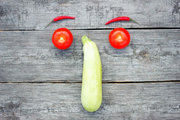 Uśmiech pomidor, zucchini i czerwony pieprz, odgórny widok, zdrowy jedzenie, jarzynowy pojęcie