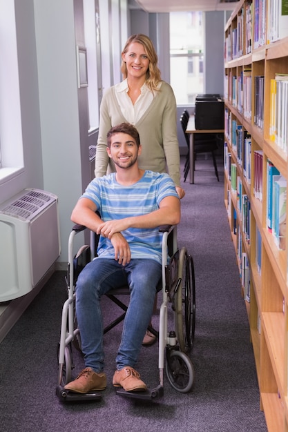 Uśmiechający Się Niepełnosprawnego Ucznia Z Kolega Z Klasy W Bibliotece