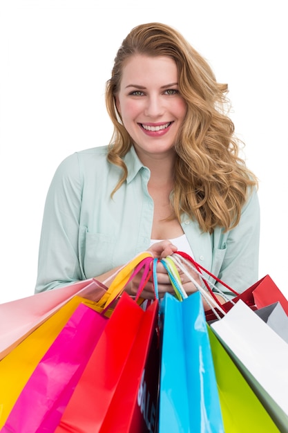 Uśmiechnięci młodej kobiety mienia torba na zakupy