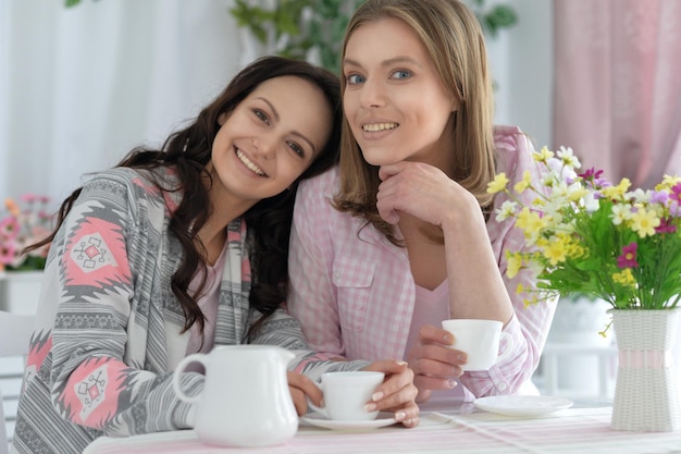 Uśmiechnięci przyjaciele piją herbatę