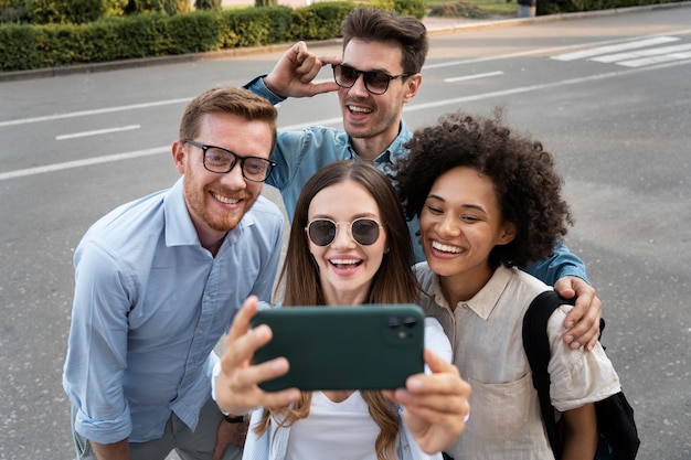 Zdjęcie uśmiechnięci przyjaciele robiący sobie selfie na świeżym powietrzu