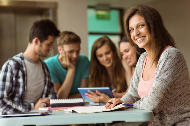 Uśmiechnięci Przyjaciele Siedzi Studiowanie I Używa Pastylka Komputer Osobistego