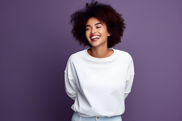 Uśmiechnięta Afroamerykanka w białym swetrze na fioletowym tle.