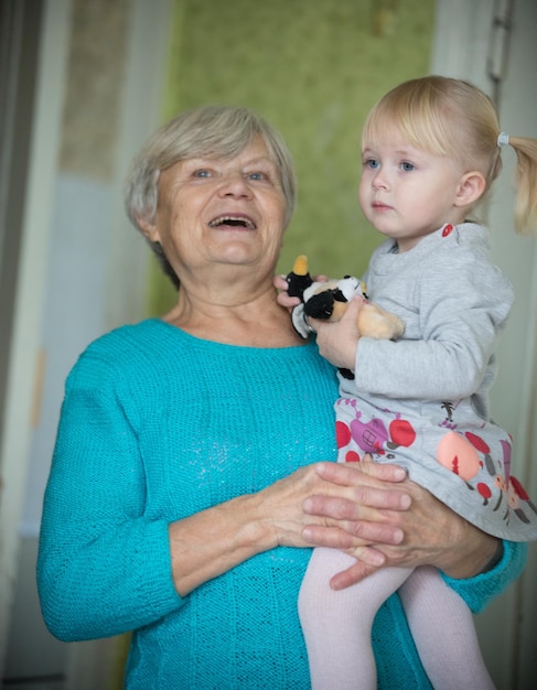 Zdjęcie uśmiechnięta babcia trzymająca małą córeczkę