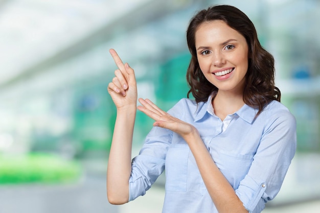 Uśmiechnięta biznesowa kobieta wskazuje palec