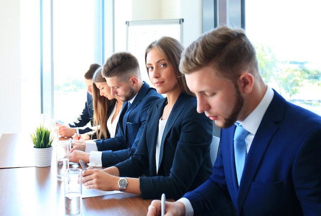 Uśmiechnięta Bizneswoman Patrząca Na Kamerę Na Seminarium Z Kolegami W Pobliżu