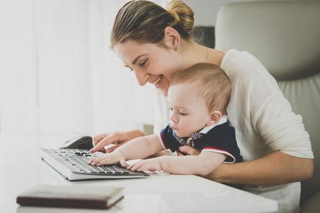 Uśmiechnięta bizneswoman pozuje z dzieckiem w biurze