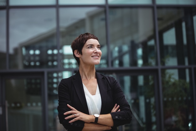 Uśmiechnięta bizneswoman pozycja w biurowych przesłankach