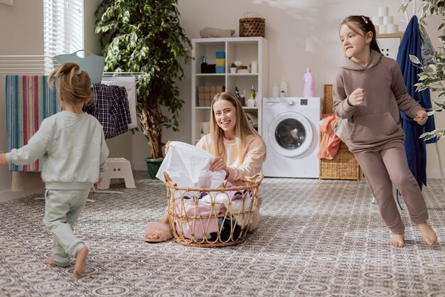 Uśmiechnięta blondynka siedzi na podłodze łazienki w pralni i sortuje