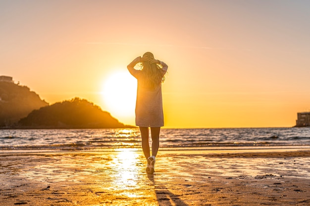 Uśmiechnięta blondynka w szarym swetrze w sesji Lifestyle na plaży