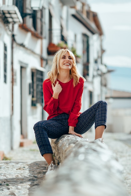 Uśmiechnięta blondynki dziewczyna z czerwoną koszula cieszy się życie outdoors.