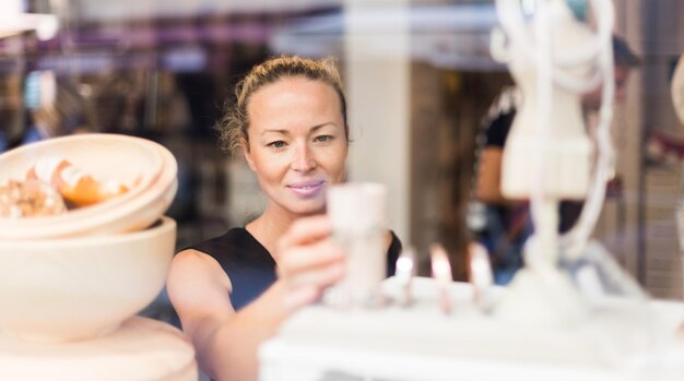 Zdjęcie uśmiechnięta dorosła kobieta stojąca w supermarkecie