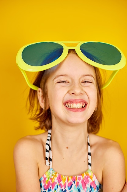 Uśmiechnięta Dziecko Nastolatka Dziewczyna W Stroju Kąpielowym I Dużych Okularach Przeciwsłonecznych Pozowanie
