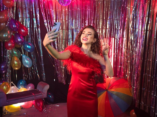 Zdjęcie uśmiechnięta dziewczyna bierze selfie na imprezie