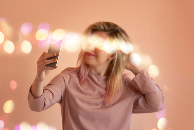 Uśmiechnięta dziewczyna robi selfie zdjęcie na smartfonie
