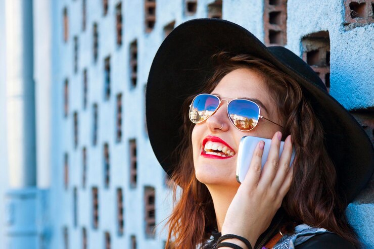 Zdjęcie uśmiechnięta dziewczyna rozmawiająca przez telefon komórkowy.