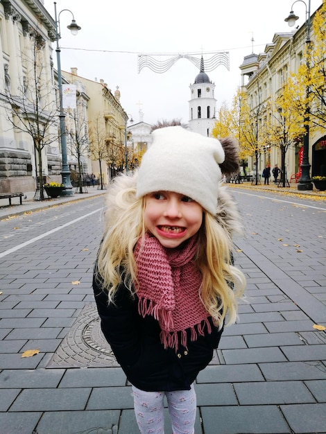 Zdjęcie uśmiechnięta dziewczyna stojąca na ulicy w mieście