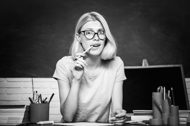 Uśmiechnięta dziewczyna studentka lub nauczycielka portret na zielonej ścianie tablica tło nauczyciel jest umiejętn...