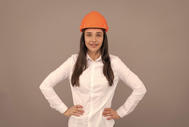 Uśmiechnięta dziewczyna w ochronnym kasku i białej koszuli robotnik