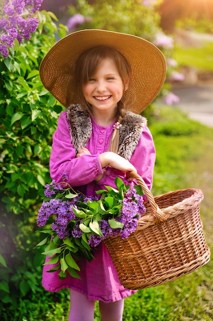 Uśmiechnięta dziewczyna z długimi blond włosami w kolorze bzu Ogród Dziewczyna z kwiatami bzu na wiosnę Ogrodnictwo
