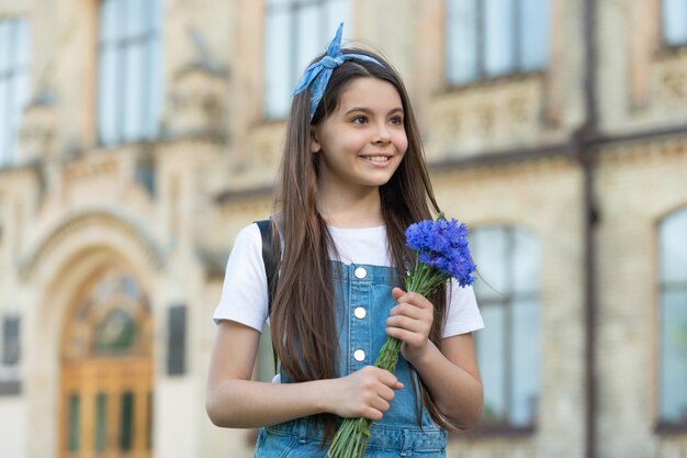 Uśmiechnięta dziewczyna z wiosennymi kwiatami na dzień kobiet