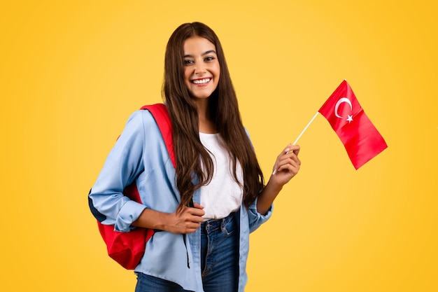 Uśmiechnięta europejska młoda studentka z turecką flagą łączy patriotyzm z edukacją