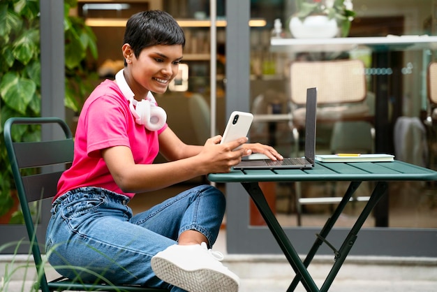 Uśmiechnięta indyjska freelancerka korzystająca z laptopa, pracująca online, oglądając szkolenia w miejscu pracy