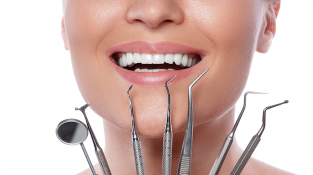 Uśmiechnięta kobieta i stomatologiczni narzędzia