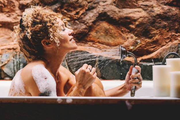 Uśmiechnięta kobieta kąpająca się w wannie