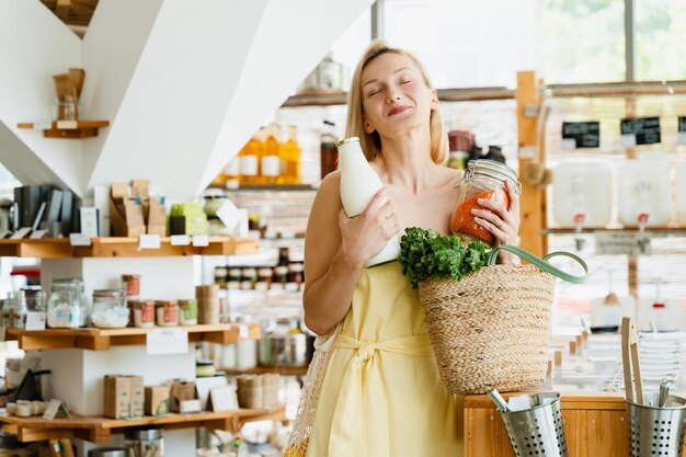 Zdjęcie uśmiechnięta kobieta kupująca produkty ekologiczne w sklepie zero odpadów