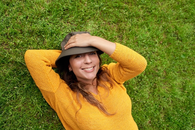 Uśmiechnięta kobieta leżąca na trawie