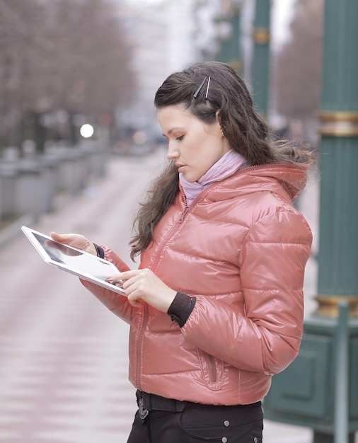 Uśmiechnięta kobieta patrząca na ekran cyfrowego tabletu