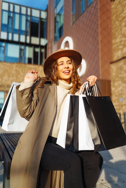 Zdjęcie uśmiechnięta kobieta po zakupach na ulicy miasta koncepcja sprzedaży zakupów koncepcja zakupów online