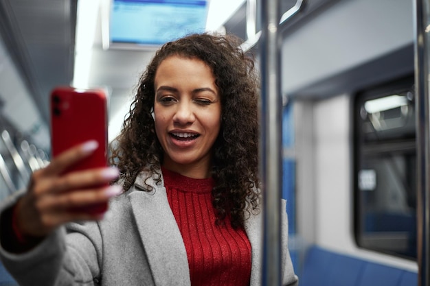 Uśmiechnięta Kobieta Robi Selfie Stojąc W Pociągu Metra