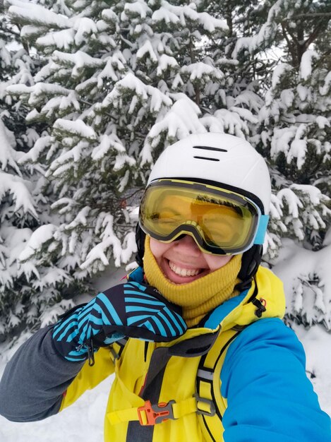 Uśmiechnięta kobieta robiąca selfie w sprzęcie narciarskim