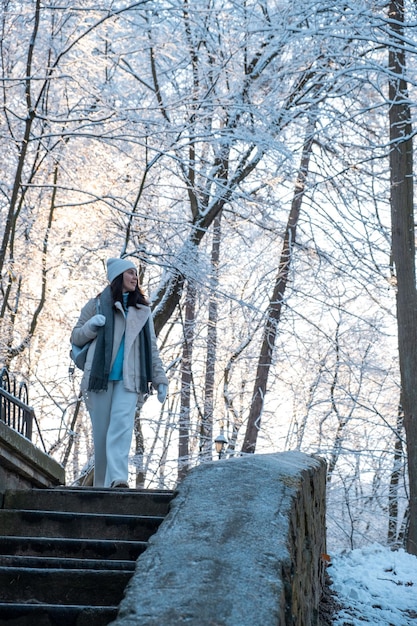 Uśmiechnięta kobieta spacerująca po zimowej przestrzeni kopii