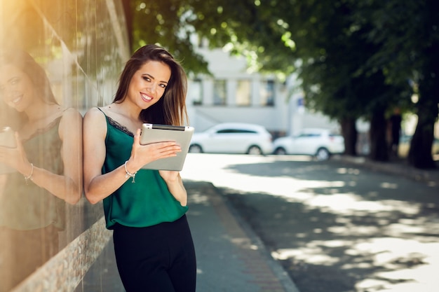 Uśmiechnięta kobieta trzyma tablet