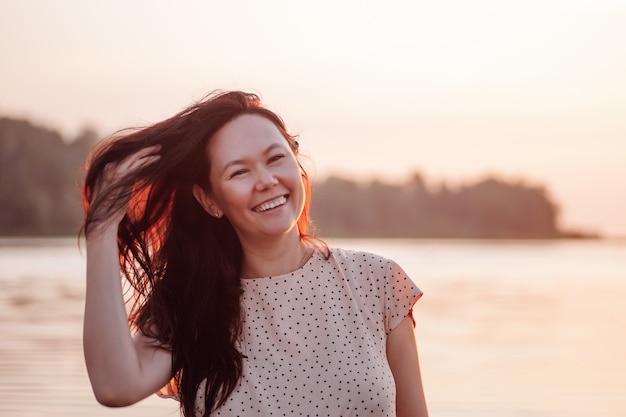Uśmiechnięta kobieta w odkrytym zbliżeniu portret szczęśliwej azjatyckiej kobiety na tle plaży i morza p...