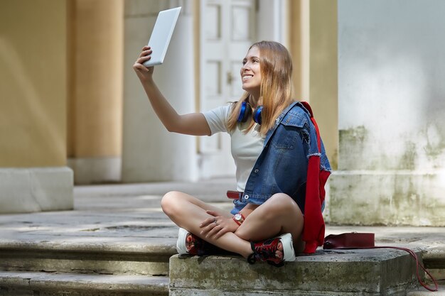Zdjęcie uśmiechnięta kobieta wesoły bierze selfie przy użyciu komputera typu tablet.