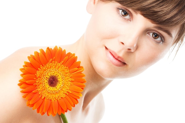 Uśmiechnięta kobieta z kreatywnym makijażem i kwiatem gerbery na kolorowym tle